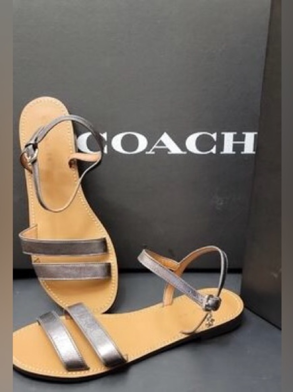 Coach metallic pewter flat sandals feature a minimalist double-strap design